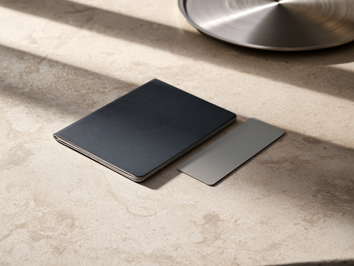 A closed notebook and a card on a stone desk